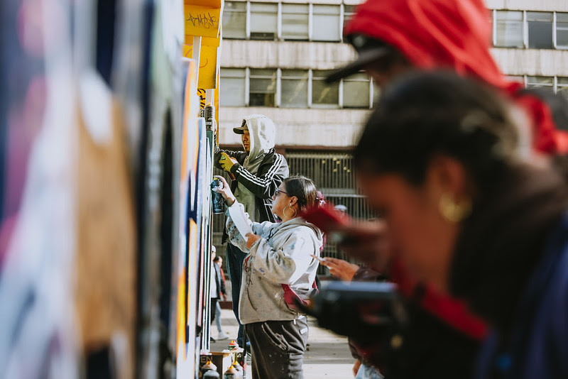 Personas pintando un mural en el centro