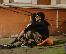 Pareja sentada en la Calle 10 frente a la FUGA observando una película. 