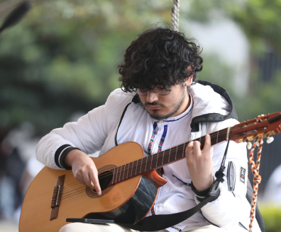 Persona tocando guitarra en una actividad de la FUGA